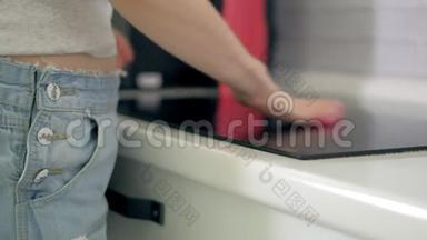 女士用海绵和喷雾<strong>清洁剂</strong>清洗<strong>厨房</strong>橱柜。